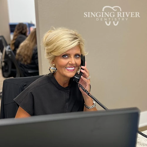 A receptionist scheduling the appointment at Singing River Dentistry.