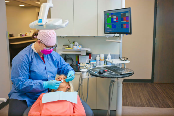 A dental assistant working on a patient at Singing River Dentistry in Florence, AL.