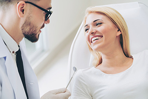 A woman smiling after receiving an oral cancer screening at Singing River Dentistry.