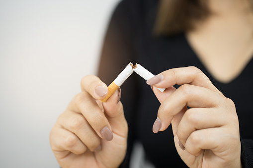 close up of someone's hands breaking a cigarette in half