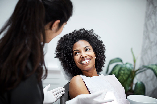  Dentist discussing tooth loss with smiling female patient at Singing River Dentistry in Russellville, AL 35653