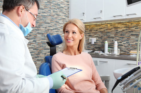 Woman talking to a dentist before her dental cleaning at Singing River Dentistry in Muscle Shoals, AL 