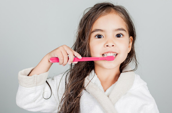 Young girl brushing her teeth after some tips from Singing River Dentistry in Muscle Shoals, AL