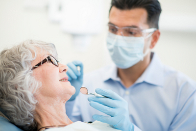 Dentist examining older patient